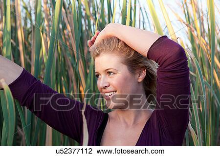 Smiling woman standing in wheat field View Large Photo Image Stock Image - Smiling woman standing in wheat field. Fotosearch