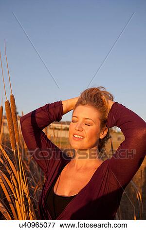 Smiling woman standing in wheat field View Large Photo Image Stock Photo - Smiling woman standing in wheat field. Fotosearch
