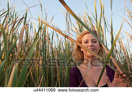 Smiling woman standing in wheat field View Large Photo Image Stock Photo - Smiling woman standing in wheat field. Fotosearch