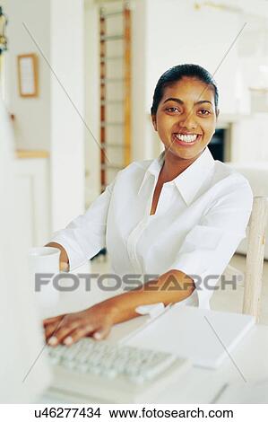 Smiling woman using computer View Large Photo Image Picture - Smiling woman using computer. Fotosearch