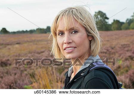 Stock Photograph - Smiling woman walking in field. Fotosearch