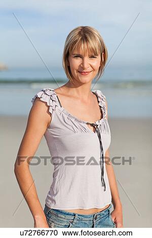 Smiling woman walking on beach View Large Photo Image Stock Image - Smiling woman walking on beach. Fotosearch