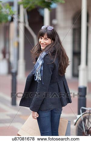 Smiling woman walking on street View Large Photo Image Stock Photo - Smiling woman walking on street. Fotosearch
