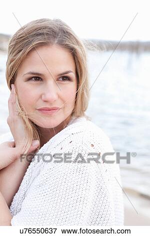 Smiling woman wearing sweater on beach View Large Photo Image Stock Photo - Smiling woman wearing sweater on beach. Fotosearch