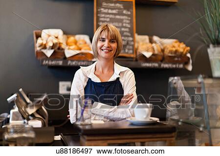 Stock Photo - Smiling woman working in cafe. Fotosearch