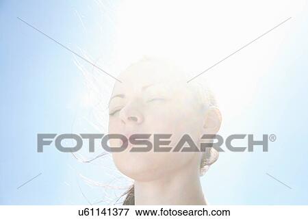 Smiling woman's face against blue sky View Large Photo Image Stock Photo - Smiling woman's face against blue sky. Fotosearch