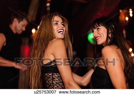 Stock Photo - Smiling women dancing in club. Fotosearch