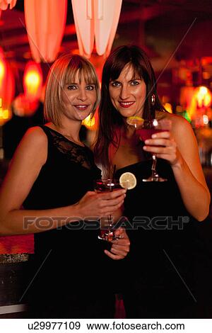 Smiling women having cocktails in bar View Large Photo Image Stock Photo - Smiling women having cocktails in bar. Fotosearch