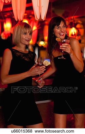Smiling women having cocktails in bar View Large Photo Image Stock Photo - Smiling women having cocktails in bar. Fotosearch