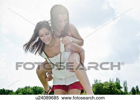 Smiling women playing outdoors together View Large Photo Image Stock Photography - Smiling women playing outdoors together. Fotosearch