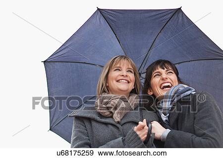 Smiling women under umbrella View Large Photo Image Stock Photo - Smiling women under umbrella. Fotosearch