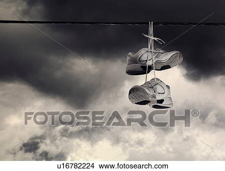 Sneakers hanging from power line View Large Photo Image Picture - Sneakers hanging from power line. Fotosearch