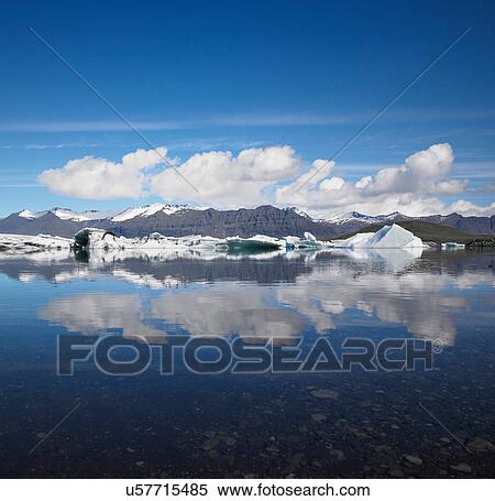 Snowy mountains reflected in still lake View Large Photo Image Stock Photography - Snowy mountains reflected in still lake. Fotosearch