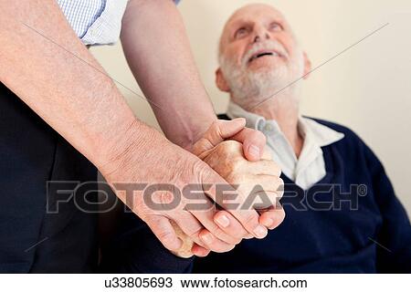 Stock Image - Son patting father's hand. Fotosearch
