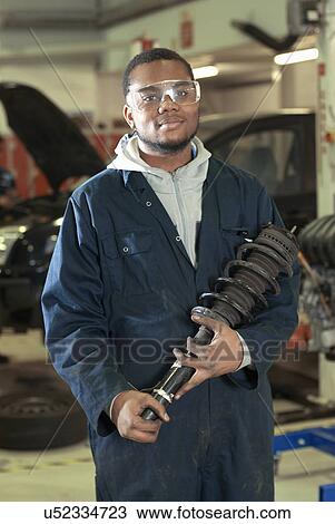Student carrying car part in garage View Large Photo Image Stock Image - Student carrying car part in garage. Fotosearch