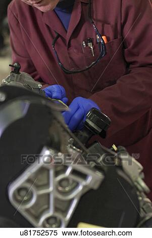 Stock Photography - Student working on car engine. Fotosearch