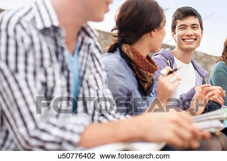 Stock Image - Students studying together outdoors. Fotosearch
