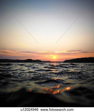 Sun setting over skyline View Large Photo Image Stock Photograph - Sun setting over skyline. Fotosearch