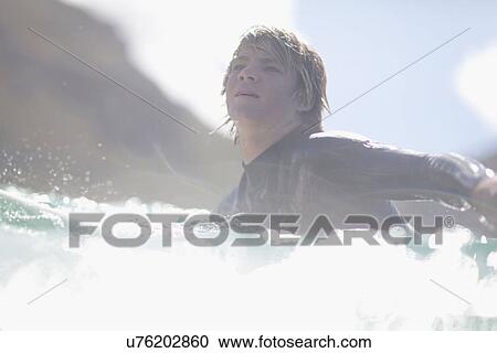 Surfer paddling in water View Large Photo Image Stock Image - Surfer paddling in water. Fotosearch