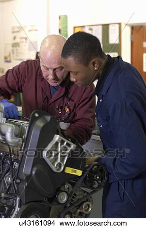 Picture - Teacher helping student with car engine. Fotosearch