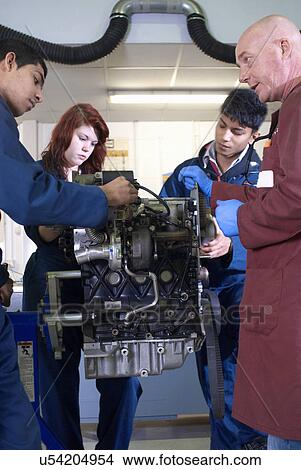 Picture - Teacher helping students with car engine. Fotosearch