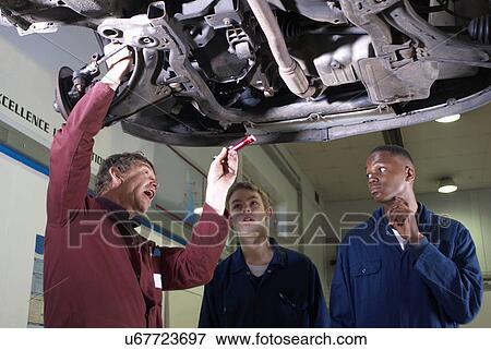 Teacher helping students with car engine View Large Photo Image Stock Photo - Teacher helping students with car engine. Fotosearch