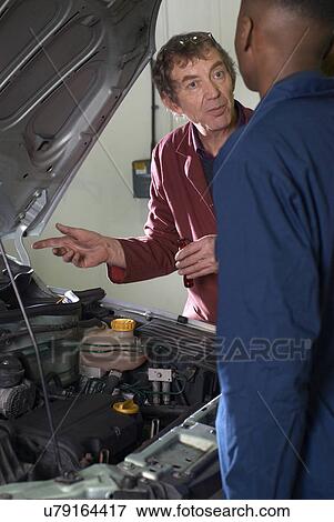 Stock Photo - Teacher helping students with car engine. Fotosearch