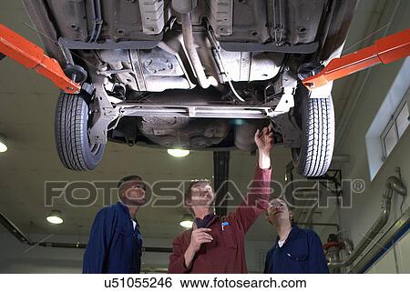 Stock Photograph - Teacher helping students with car engine. Fotosearch
