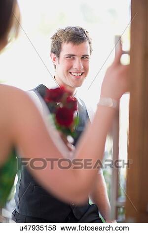 Stock Photo - Teenage boy bringing flowers to date. Fotosearch