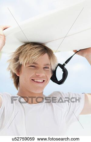 Teenage boy carrying surfboard View Large Photo Image Stock Photo - Teenage boy carrying surfboard. Fotosearch