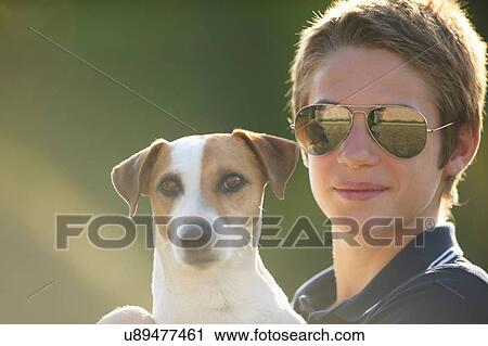 Teenage boy holding dog outdoors View Large Photo Image Stock Image - Teenage boy holding dog outdoors. Fotosearch