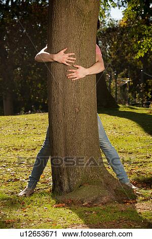 Teenage boy hugging tree in park View Large Photo Image Stock Image - Teenage boy hugging tree in park. Fotosearch