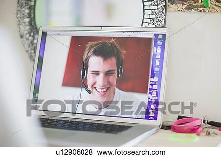 Teenage boy talking on laptop View Large Photo Image Stock Photo - Teenage boy talking on laptop. Fotosearch