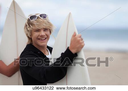 Teenage boys carrying surfboards View Large Photo Image Stock Image - Teenage boys carrying surfboards. Fotosearch