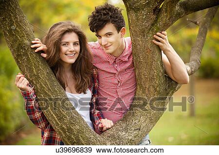 Stock Photo - Teenage couple climbing in park. Fotosearch