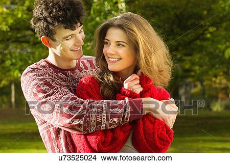 Picture - Teenage couple hugging in park. Fotosearch