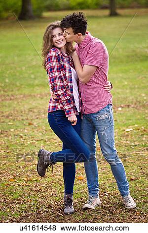 Stock Photo - Teenage couple kissing in park. Fotosearch