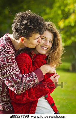 Teenage couple kissing in park View Large Photo Image Stock Photograph - Teenage couple kissing in park. Fotosearch