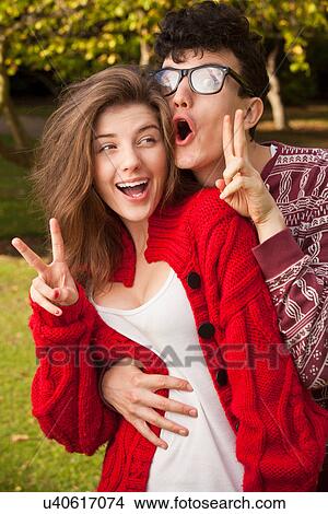 Teenage couple making faces in park View Large Photo Image Picture - Teenage couple making faces in park. Fotosearch