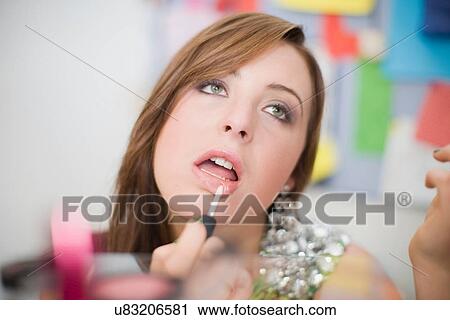 Stock Image - Teenage girl applying makeup. Fotosearch