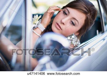 Teenage girl checking makeup in car View Large Photo Image Stock Photograph - Teenage girl checking makeup in car. Fotosearch