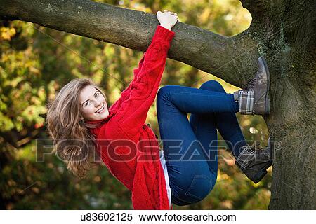 Teenage girl climbing tree in park View Large Photo Image Stock Photography - Teenage girl climbing tree in park. Fotosearch