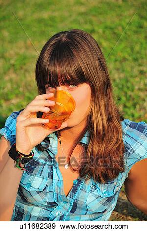 Teenage girl drinking juice in backyard View Large Photo Image Stock Photo - Teenage girl drinking juice in backyard. Fotosearch