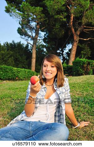Teenage girl eating fruit in backyard View Large Photo Image Stock Image - Teenage girl eating fruit in backyard. Fotosearch