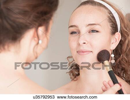 Stock Image - Teenage girl having her makeup done. Fotosearch