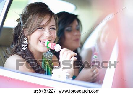 Stock Photo - Teenage girl in gown eating kebab. Fotosearch