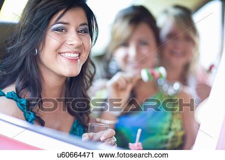 Stock Image - Teenage girl in gown sitting in car. Fotosearch