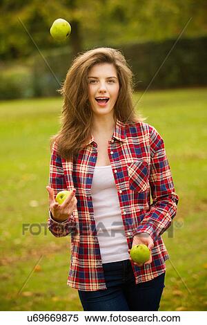 Stock Photography - Teenage girl juggling apples in park. Fotosearch
