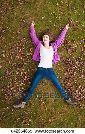 Teenage girl laying in grass in park View Large Photo Image Stock Photography - Teenage girl laying in grass in park. Fotosearch