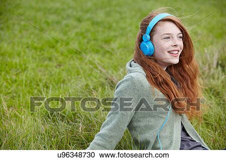 Teenage girl listening to headphones View Large Photo Image Stock Image - Teenage girl listening to headphones. Fotosearch
